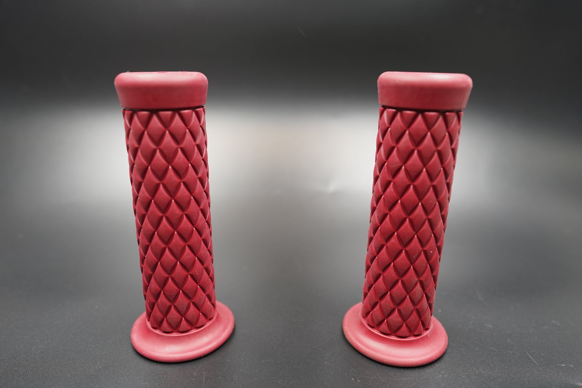Upright front view of red diamond motorcycle grips showing texture