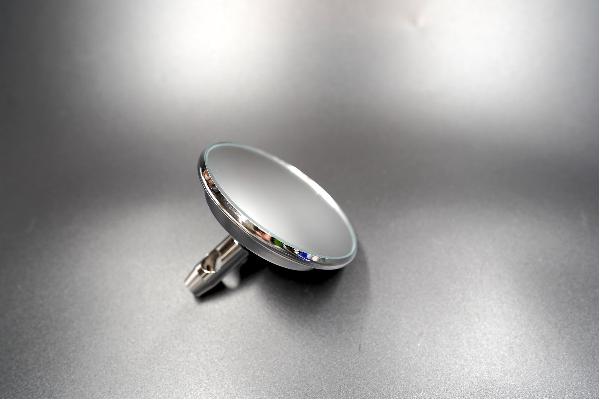 Side profile of chrome-plated motorcycle mirror showing slim form and smooth edge.