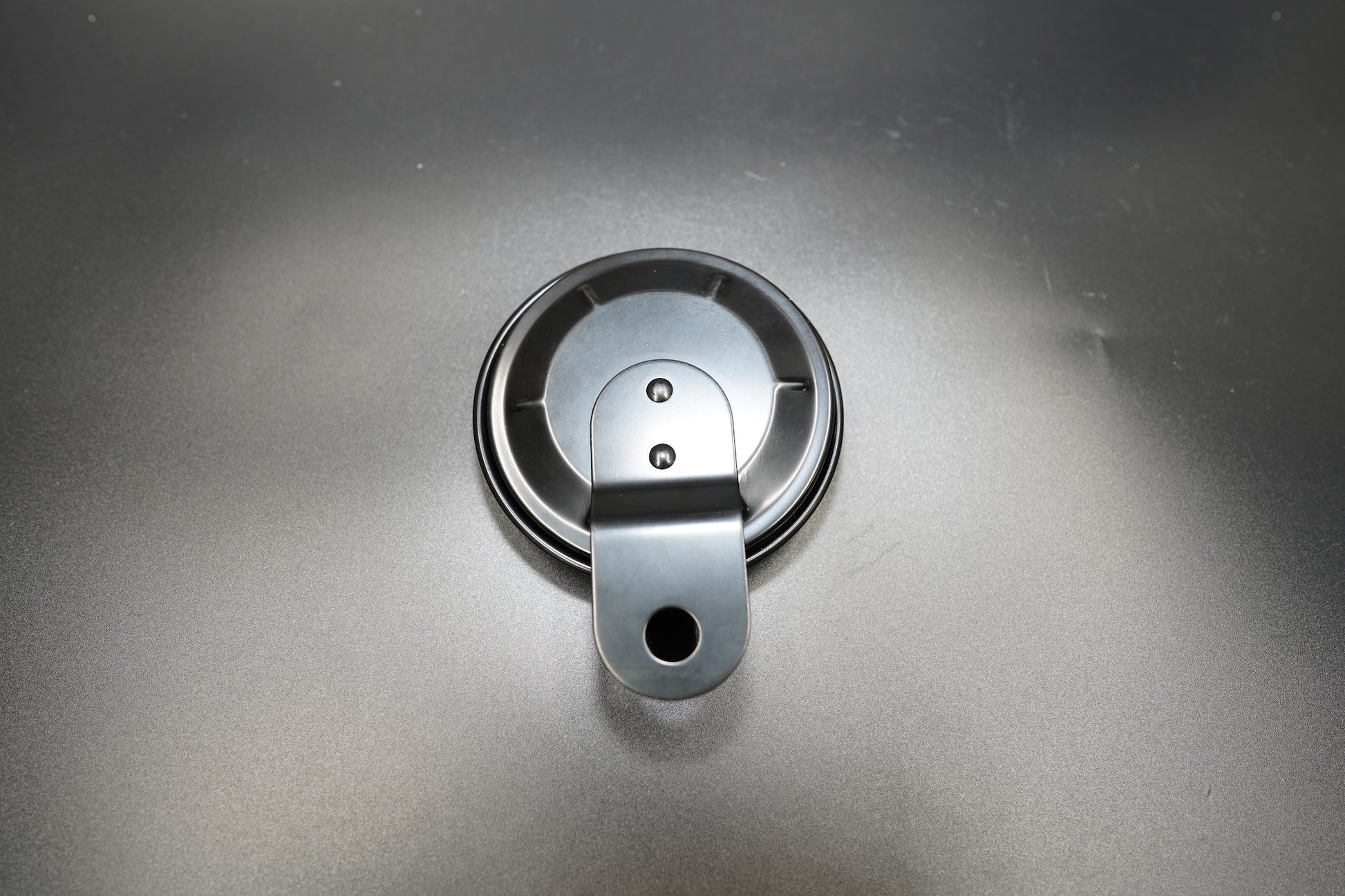 Front-facing view of metal number plate with single mounting hole