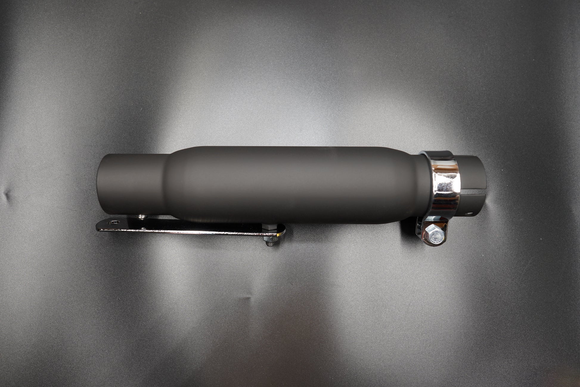 Matte black silencer side view with clamp and bracket.