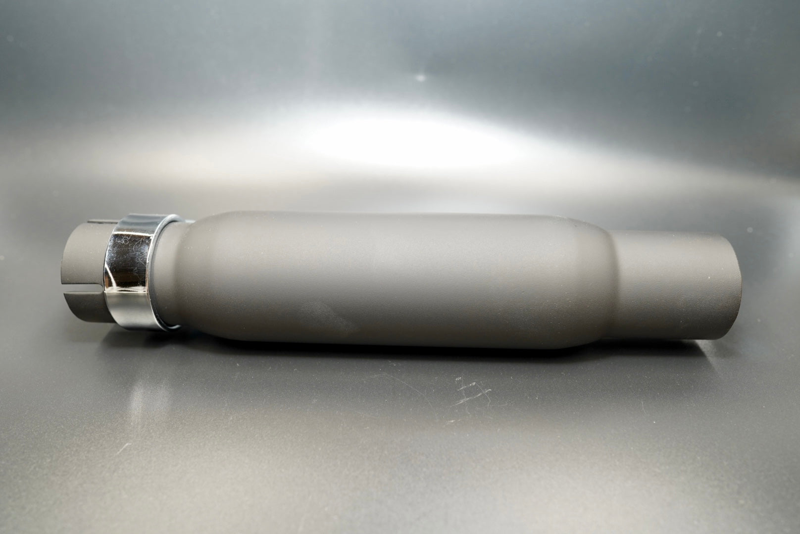 Vintage universal shorty exhaust silencer in matte black finish, side profile on matte background.