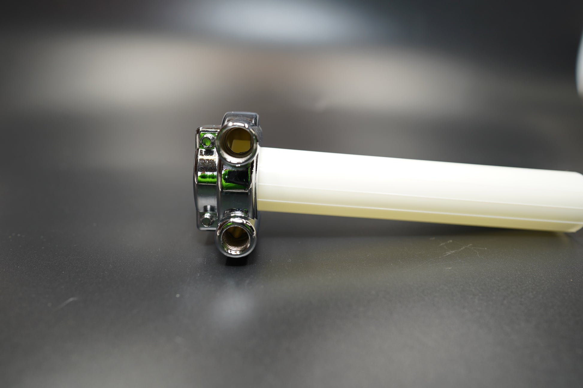 Angled shot highlighting chrome finish and throttle cable entry ports